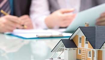Miniature house model with property tax documents in the background
